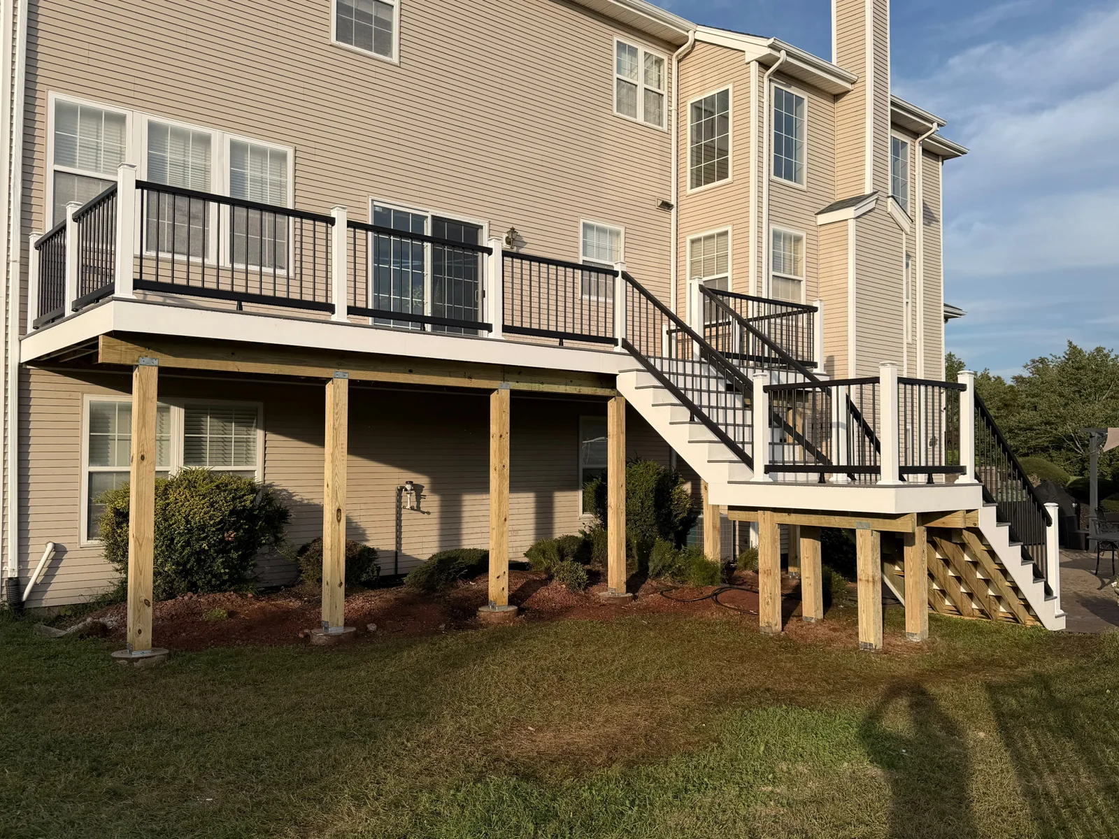 Elevated backyard deck with two stair runs and black railings