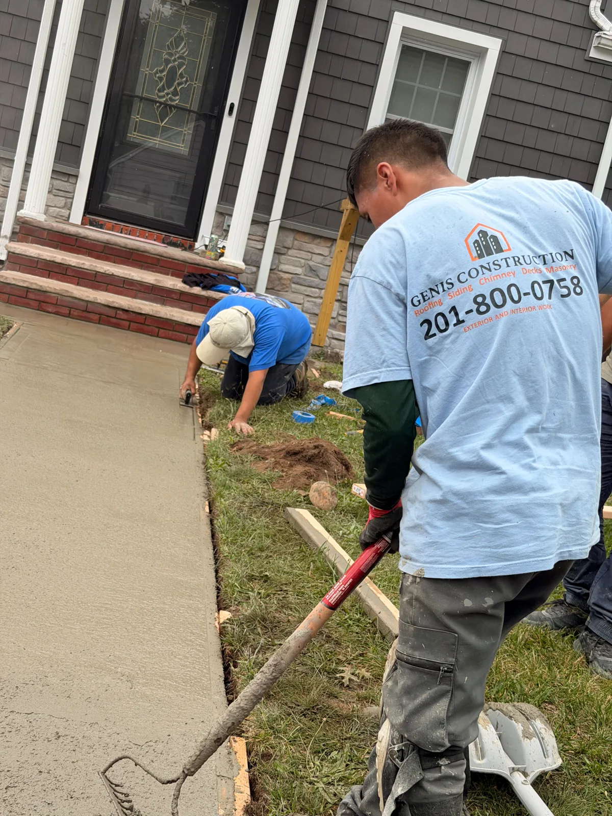 Genis Construction team finishing a concrete walkway